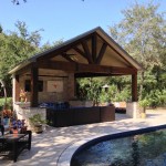 The timber frame construction of this covered patio matches the home's architectural style and landscape. It also lends a cozy air to the seating area by the pool. It was designed and built by Outdoor Homescapes of Houston in Cypress, TX. For more outdoor living space designs, ideas and inspiration, visit www.outdoorhomescapes.com.