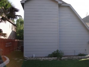 Before shot. Back view of a garage from the back yard. A covered patio with an outdoor bar and grill area will come into the backyard from this garage, and another covered outdoor living space - a living room - will span the distance between the garage and the house to the right. For more on Outdoor Homescapes of Houston, go to www.outdoorhomescapes.com