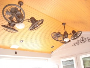 This a closeup of a wood ceiling with rustic styled outdoor ceiling fans on a patio cover and roof extension designed and built by Outdoor Homescapes of Houston. For more on this outdoor designer, go to www.outdoorhomescapes.com