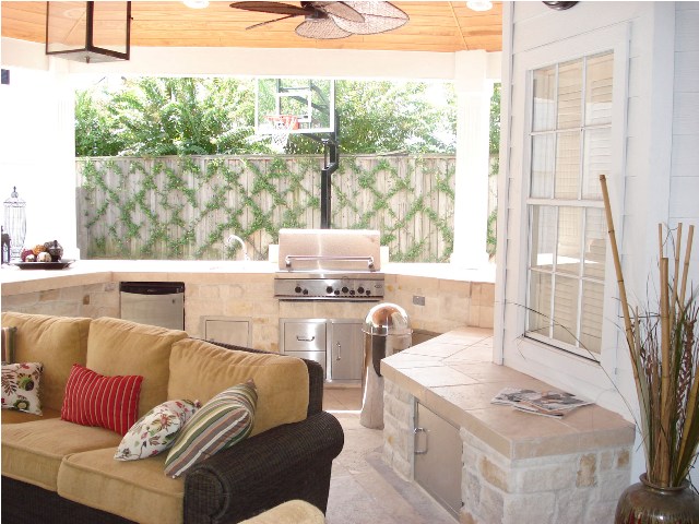 This Houston outdoor living space comprises a covered patio via roof extension with an outdoor kitchen, outdoor living room, outdoor bar and grill area and bench storage. To see the blog post this images was part of, go to http://www.outdoorhomescapes.com/outdoor-living-spaces-boost-quality-life-home-values/. To see more outdoor living spaces designed and built by Outdoor Homescapes of Houston, go to www.outdoorhomescapes.com.