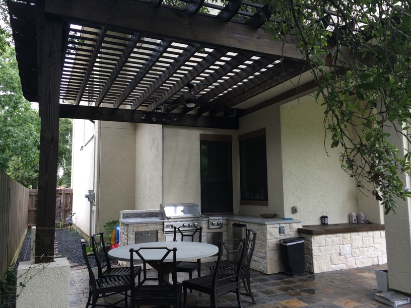 Houston outdoor kitchens have gone modern - like this one with poured-concrete countertops and a dark-stained pergola (Minwax Jacobean). More at www.outdoorhomescapes.com.