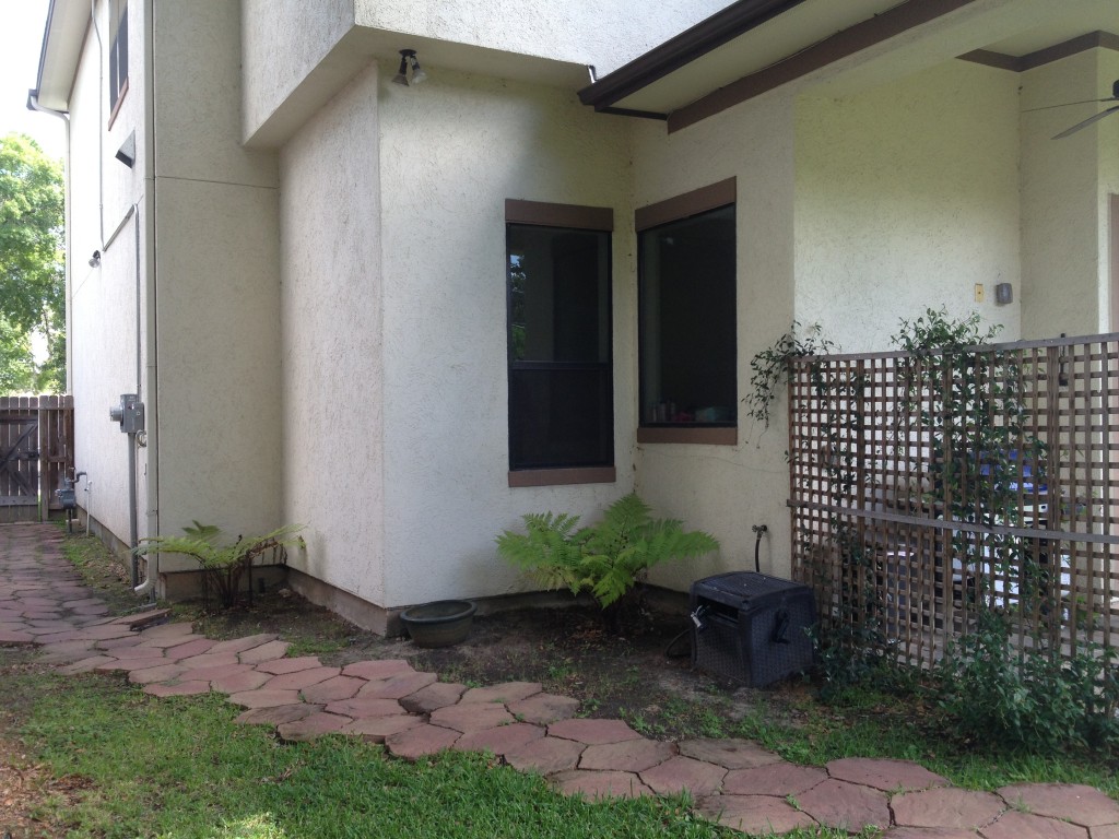 This is a before picture of a Houston outdoor kitchen project with concrete countertops, a dark-brown pergola and custom storage by Houston outdoor designer Outdoor Homescapes of Houston. More at www.outdoorhomescapes.com