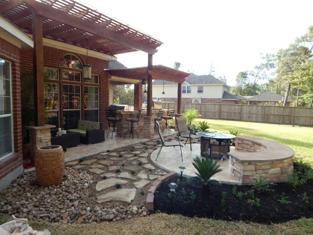 A two-tier pergola, circular firepit area and outdoor kitchen with a Fire Magic charcoal-gas combo grill are featured in this Houston patio design by Outdoor Homescapes of Houston. More at www.outdoorhomescapes.com/blog