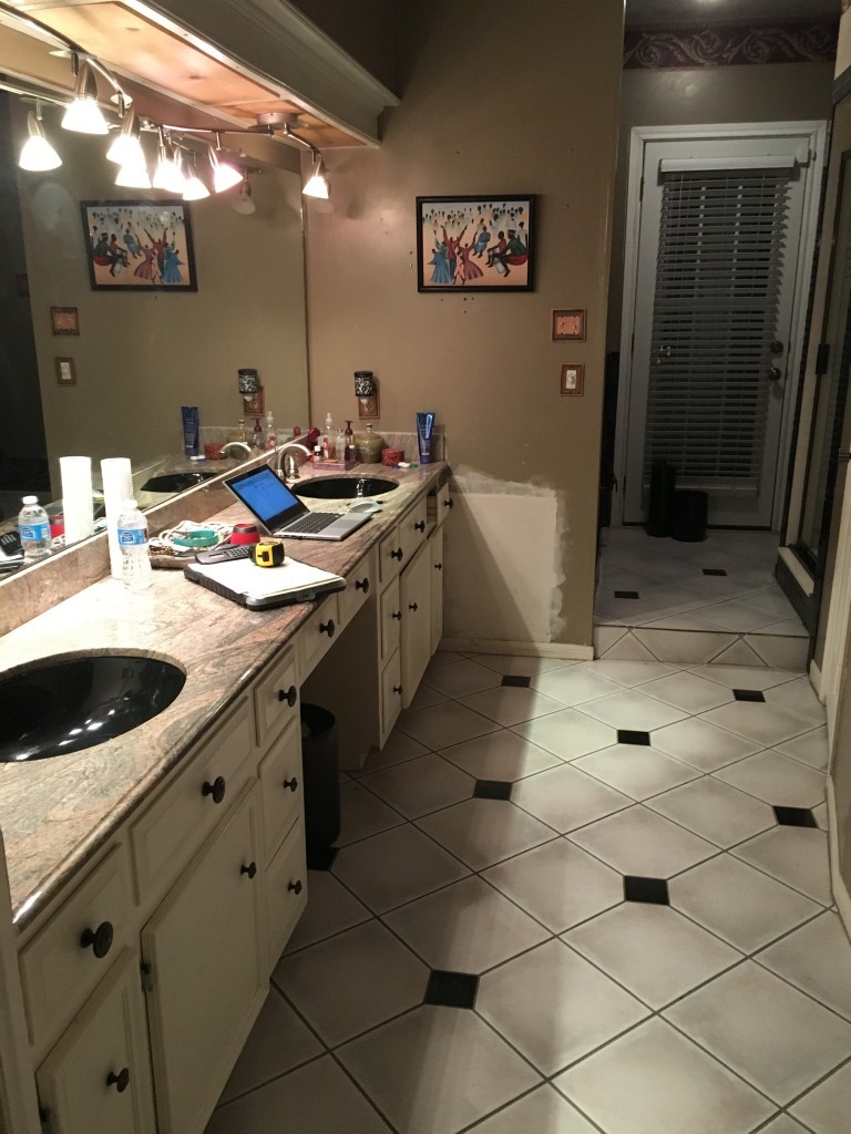 This "before" shot of a bathroom remodel by Outdoor Homescapes of Houston shows the outdated 8-inch square tiles, black undermount sinks and wallpaper border that were replaced. More at www.outdoorhomescapes.com/blog