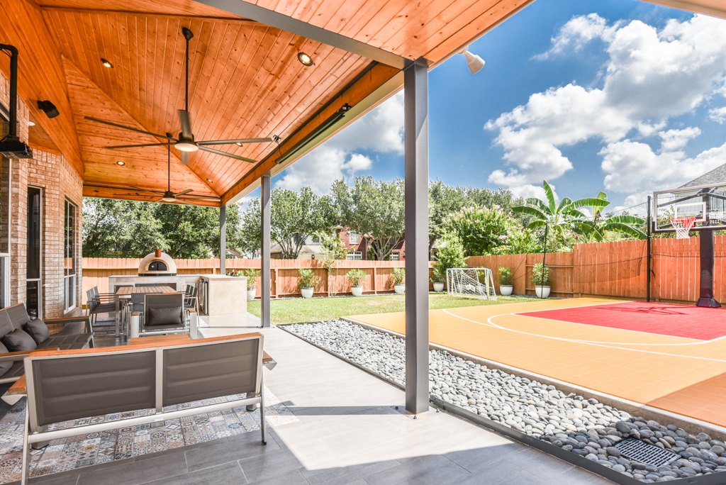 This unique Houston patio features a French drain next to a basketball court. More details on this patio project at www.outdoorhomescapes.com/blog