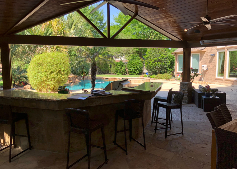 This covered patio in Houston by Homescapes of Houston lets those sitting in the outdoor kitchen look out onto the pool area. More at www.outdoorhomescapes.com